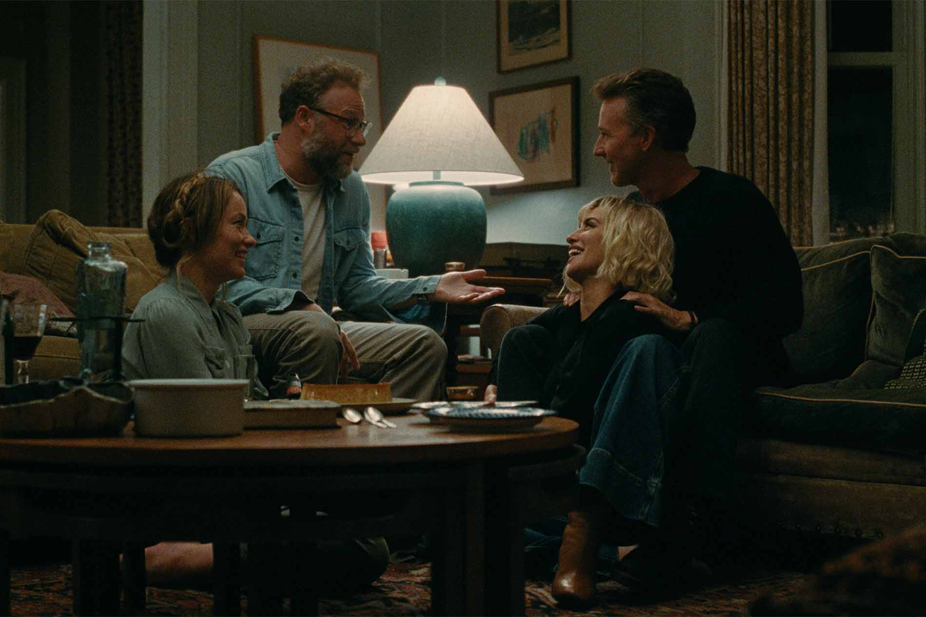 Scena di The Invite - Il Piacere è Tutto Nostro: le due coppie protagoniste, interpretate da Seth Rogen, Olivia Wilde, Penélope Cruz ed Edward Norton, ridono insieme in salotto.